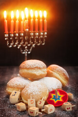 Symbols of jewish holiday hanukkah - menorah, donuts sufganiyot and dreidels
