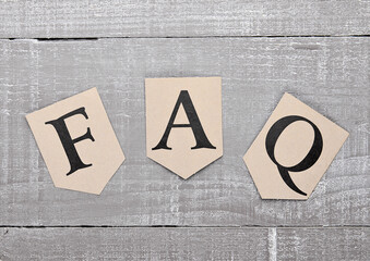 FAQ paper letter symbol motivation on wooden board. Motivation card
