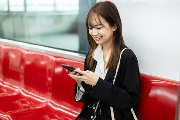 young asian women using smartphone during on the way lifestyle travel by train public...