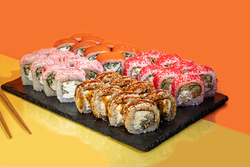 Sushi sets, rolls with caviar, shrimp, tuna and avocado and Philadelphia cheese, on a white plate.