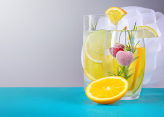 Drinks with citrus slices and cherries in glass glasses on a gray background with copy space
