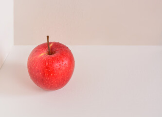 Apple with water drops on light background with copy space