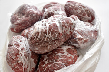 Frozen minced beef in food plastic wrap or cling film in a plastic bag.  Photo can be used for how...