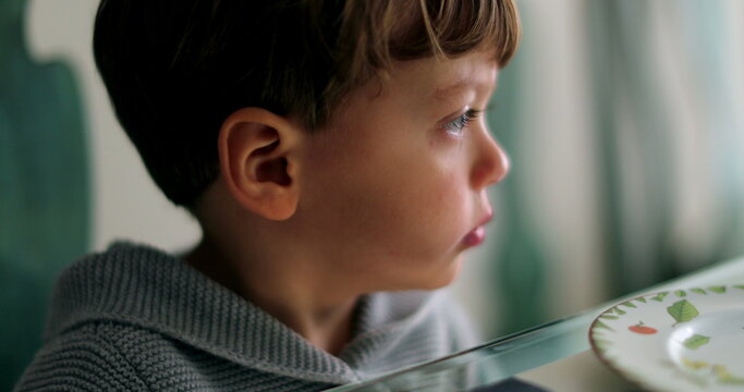 Pensive Sad Little Boy Looking Out Window