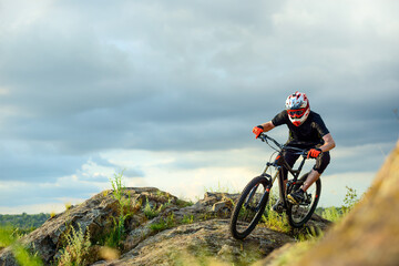 Fototapeta na wymiar Professional Cyclist Riding the Bike on the Rocky Trail. Extreme Sport Concept.