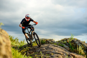 Obraz na płótnie Canvas Professional Cyclist Riding the Bike on the Rocky Trail. Extreme Sport Concept.