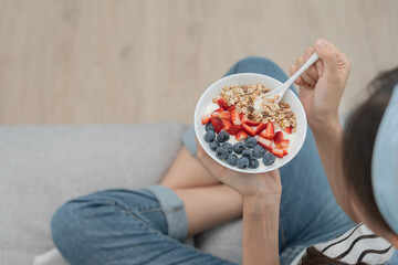 healthy food. Beautiful female girl enjoy eat yogurt, granola, fresh fruits on breakfast health in...