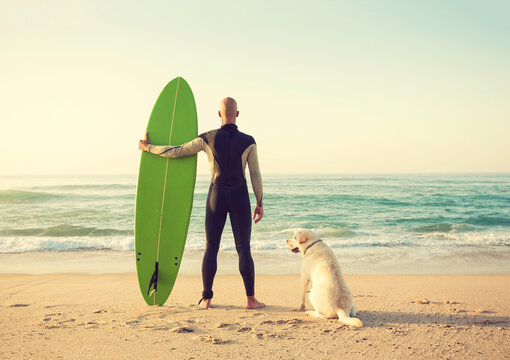Surfist on the beach with his best friend