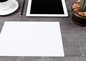 Graphic tablet with cactus paper sheet and coffee on office desk