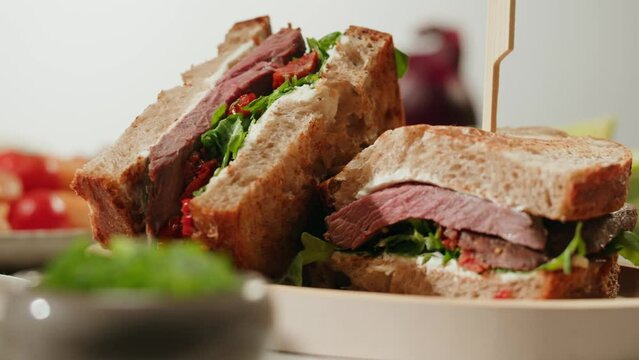 American pastrami sandwich with ham meet cuts in restaurant, cooking Famous thick cut sous vide beef sandwich on restaurant cafe kitchen. Studio shot close up, macro.