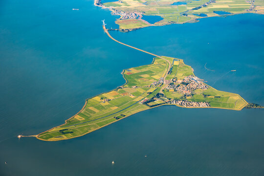 Aerial image of the Dutch island Marken in Noord Holland. Green fields and blue water of the IJsselmeer with sailboats
