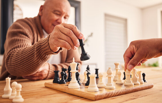 Senior man, home and chess for games, competition and focus with friends, strategy and problem solving. Elderly person, hands and board for contest with mindset, excited smile and moving at table
