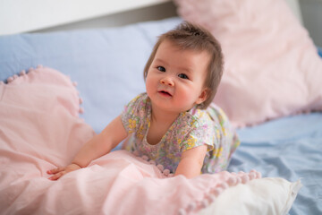 lifestyle home portrait of happy and adorable 9 months old mixed ethnicity Asian Caucasian baby girl playing cheerful and carefree on bed looking sweet and cute in childhood concept
