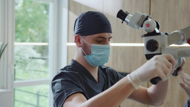 In modern clinic man dentist with medical mask use special dental equipment that treats teeth. Hydience and healthy