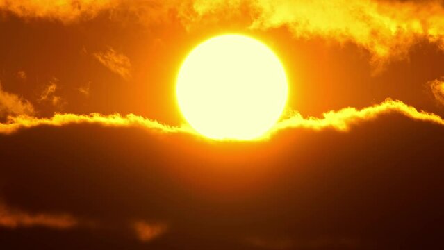 Cinematic sun set at red yellow and orange sky timelapse. Hot summer atmosphere at heat wave. Yellow sun setting at epic golden hour time lapse. Close up view of big round sun disk.
