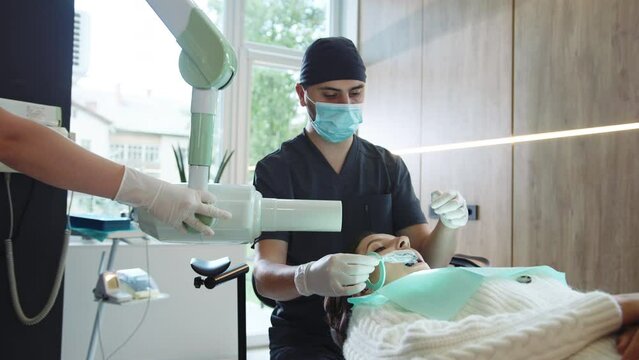 In modern clinic assistants and dentist with in medical mask holds dental instrument that treats teeth. Hydience and healthy