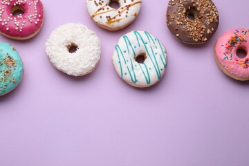 Different tasty glazed donuts on purple background, flat lay. Space for text