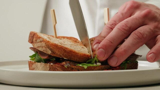 American pastrami sandwich in New York ham meet cuts. chef cooking Famous thick cut sous vide beef sandwich on restaurant cafe kitchen. Studio shot close up, macro, white background. 