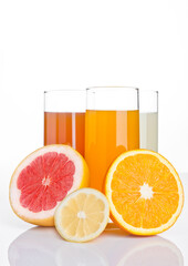 Glasses of healthy grapefruit and orange and lemon juice on white background