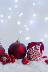 Christmas scene with snow - white and red balls with lights in background