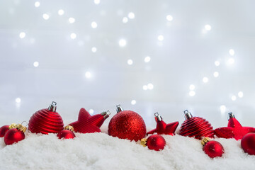 Fototapeta na wymiar Christmas scene with snow - row of red balls with lights in background