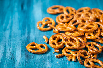 Salty snacks mini pretzels on blue wooden table