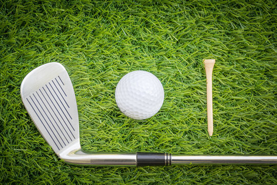 Sport objects related to golf equipment ,Golf club and golf ball on green grass