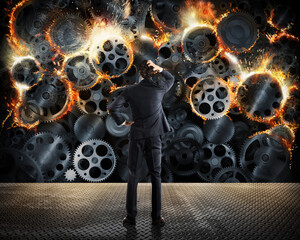 Stress concept with overworked businessman desperately looks a gear mechanism burn