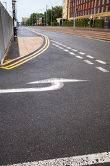 road markings at a give way junction with white painted direction arrow
