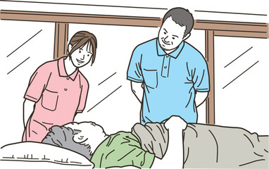 高齢者をベッドで介助する男女の介護士