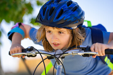 Sporty kid riding bike on a park. Child in safety helmet riding bicycle. Kid learns to ride a bike. Kids on bicycle. Happy child in helmet cycling outdoor. Sports leisure with kids.