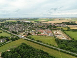 Fototapeta na wymiar Drone high altitude view of a typical English village showing a large expansion of houses to the right of the image.
