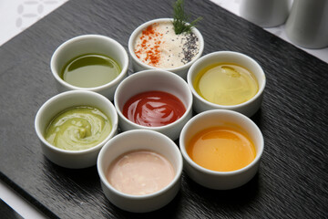 Different sauces and dips in bowls on the restaurant table
