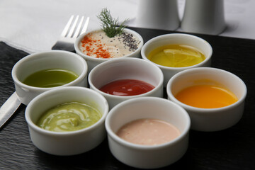 Different sauces and dips in bowls on the restaurant table
