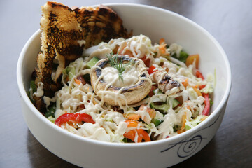 Vegetable salad and toast bread served in a bowl