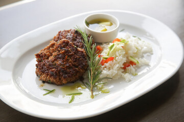 Fried meatballs served with white rice and rosemary on the restaurant table