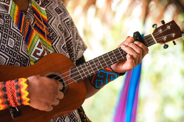 Indígena tocando instrumento de cordas