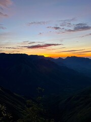 Obraz premium Blazing sunrise painting the sky in mystic shades of orange, yellow, pink and casting long shadows across the peaks and valleys