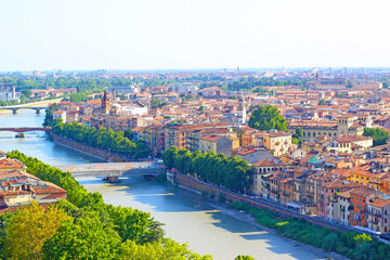 Fototapeta na wymiar Aerial view of Verona historical city centre, bridges across Adige river, medieval buildings with red tiled roofs, Veneto Region, Italy. Verona cityscape and panoramic view.