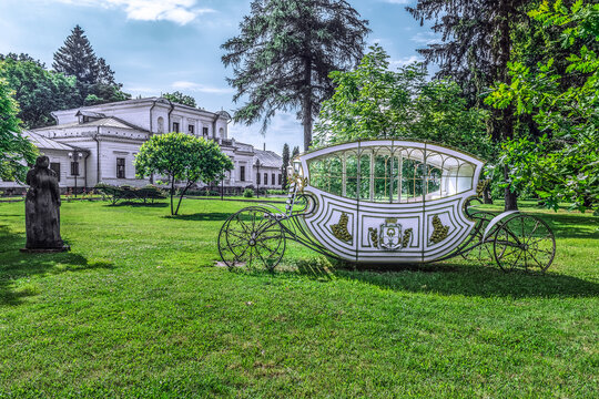 Fairy-tale carriage on the lawn in front of the former estate of Prince Alexey Golitsyn in Trostyanets, Sumy Oblast, Ukraine. Romantic photo zone on the Alley of lovers in the city park
