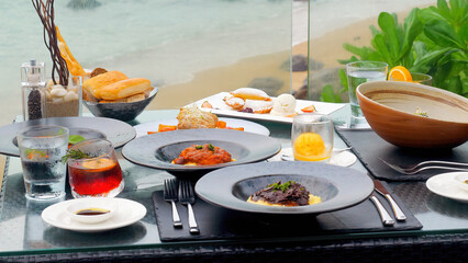 Romantic beachfront dinner for two at a luxury restaurant on Phuket Island. Delicious food served on a table with a stunning sea view, perfect setting for a romantic celebration.