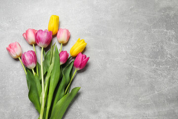 Beautiful colorful tulip flowers on grey table, flat lay. Space for text