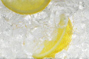 Juicy lemon slices and ice cubes in soda water against white background, closeup