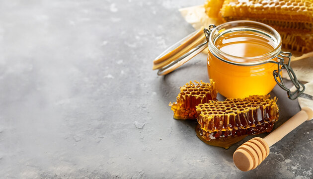 Honey products background. Honeycomb frame, bee pollen granules, honey in glass pot on grey concrete background. Copy space. Autumn harvest concept.