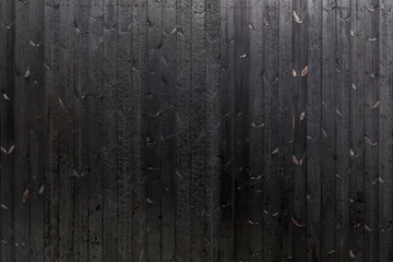 Tuinposter Vertical black dark burned wood vertical linear pattern facade.  © Peeradontax