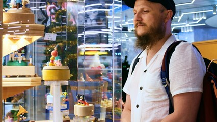 Cinematic video: an inspired man looks at colorful toys in a shop window. Slow motion: An inspired...