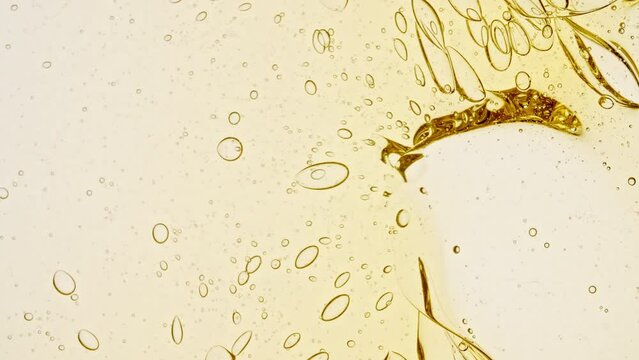 Transparent cosmetic gel fluid with molecule bubbles oil distribution on a white background. Macro Shot of Natural Organic Cosmetics, Medicine. Production Close-up. Slow Motion. High quality 4k