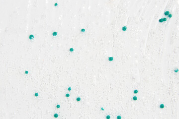 Transparent gel with blue granules smeared serum on a white background