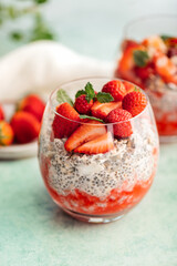Healthy chia pudding in a glass with fresh strawberries made from almond milk and berry juice. Perfect breakfast for healthy start of the day