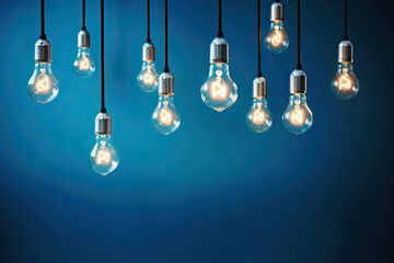 hanging light bulbs on blue background with copy space. winning idea concept